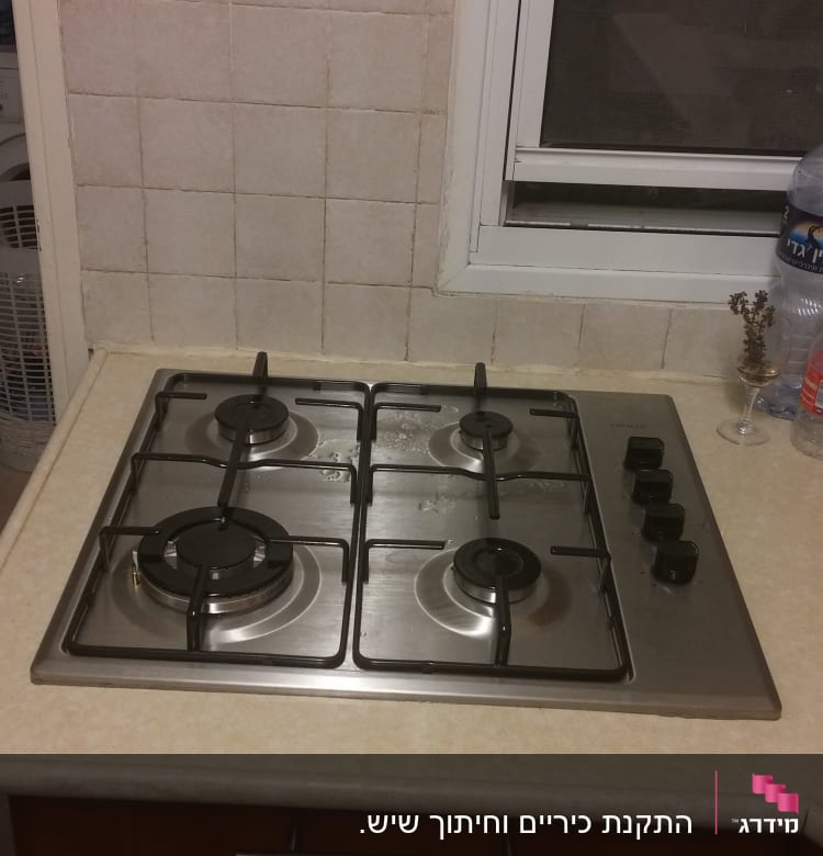 כיריים גז עם ארבעה מבערים וכפתורי שליטה